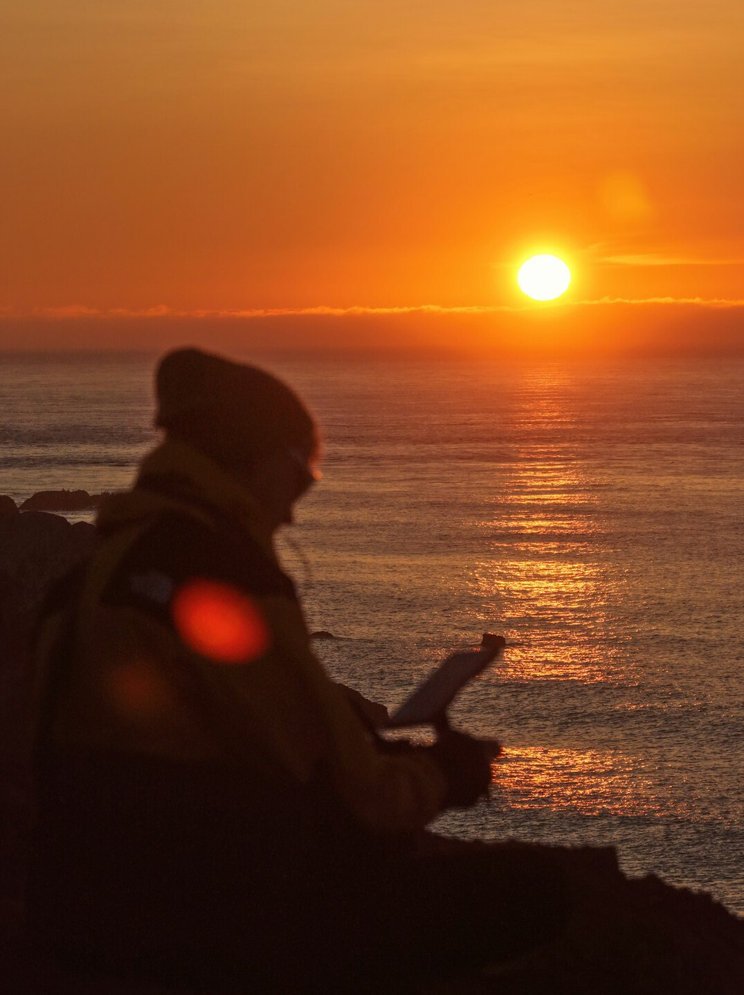 person writing in journal at sunrise